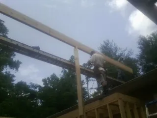 Carpenter setting a ridge beam over a new addition frame — Ice Dam Removal by Roofing Brothers in Bay Village