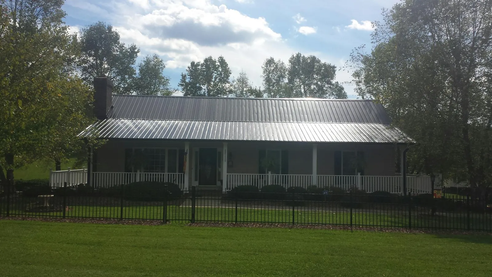 Gray metal roof on a brick ranch with a full width front porch — Gutter Guard Installation work by our crew in Bay Village