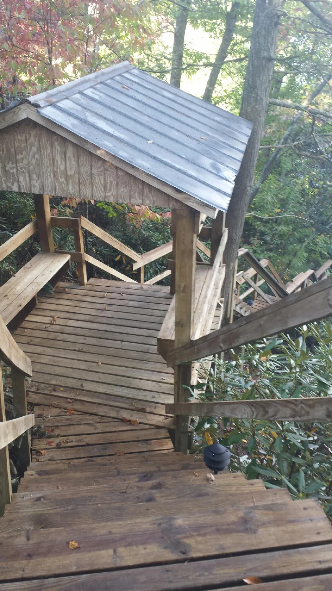 Metal roofed shelter over wooden steps on a wooded walkway — Skylight Repair & Installation work by our crew in Bay Village