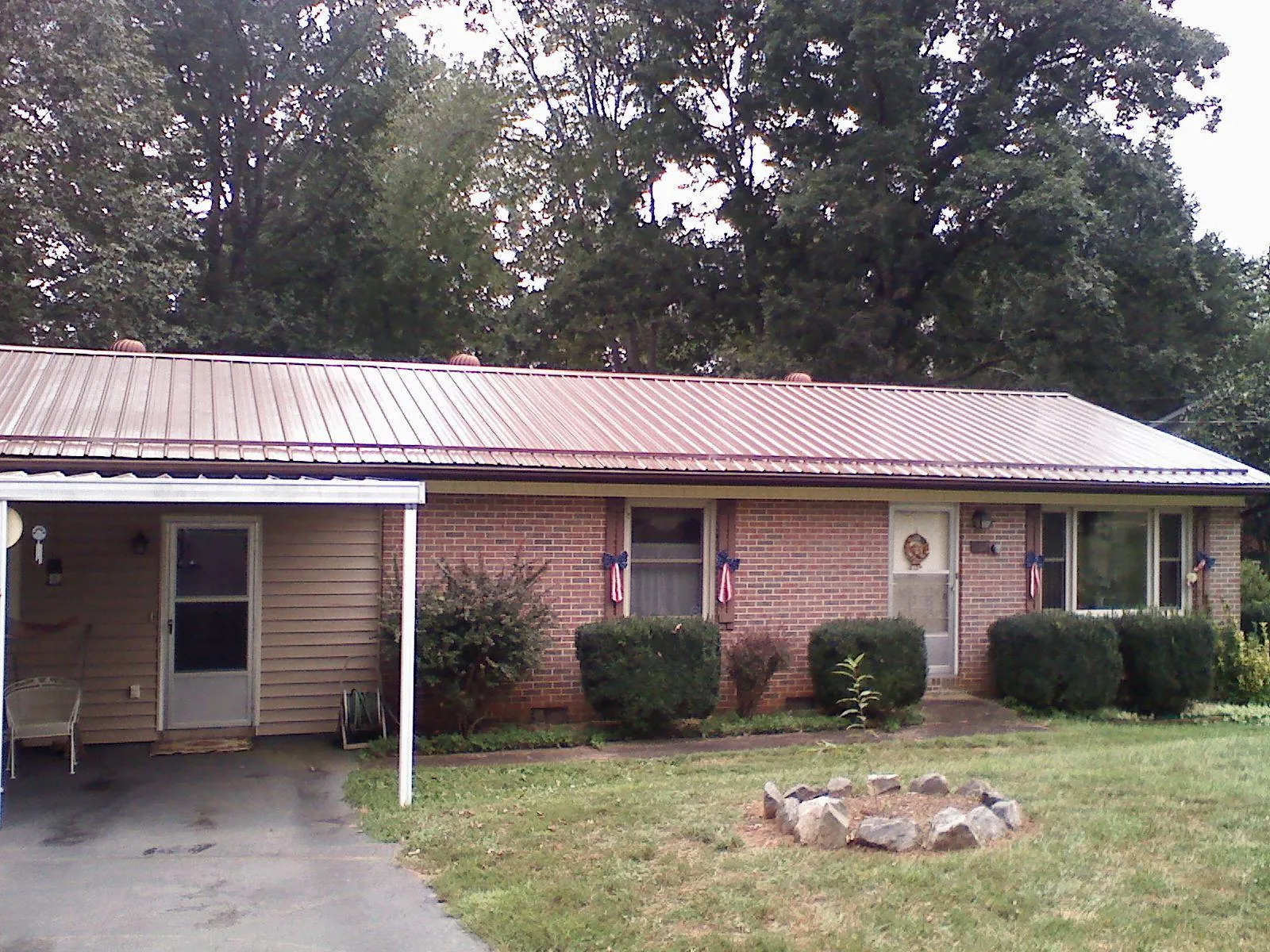 Bronze metal roof and carport on a brick ranch home — Roof Repair work by our crew in Bay Village